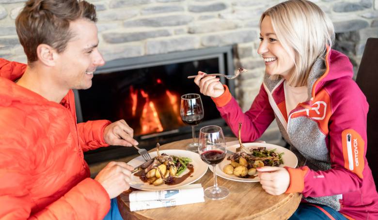 Paar beim Essen am Kaminfeuer