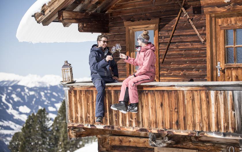 Paar macht Pause vom Skifahren auf der Alm